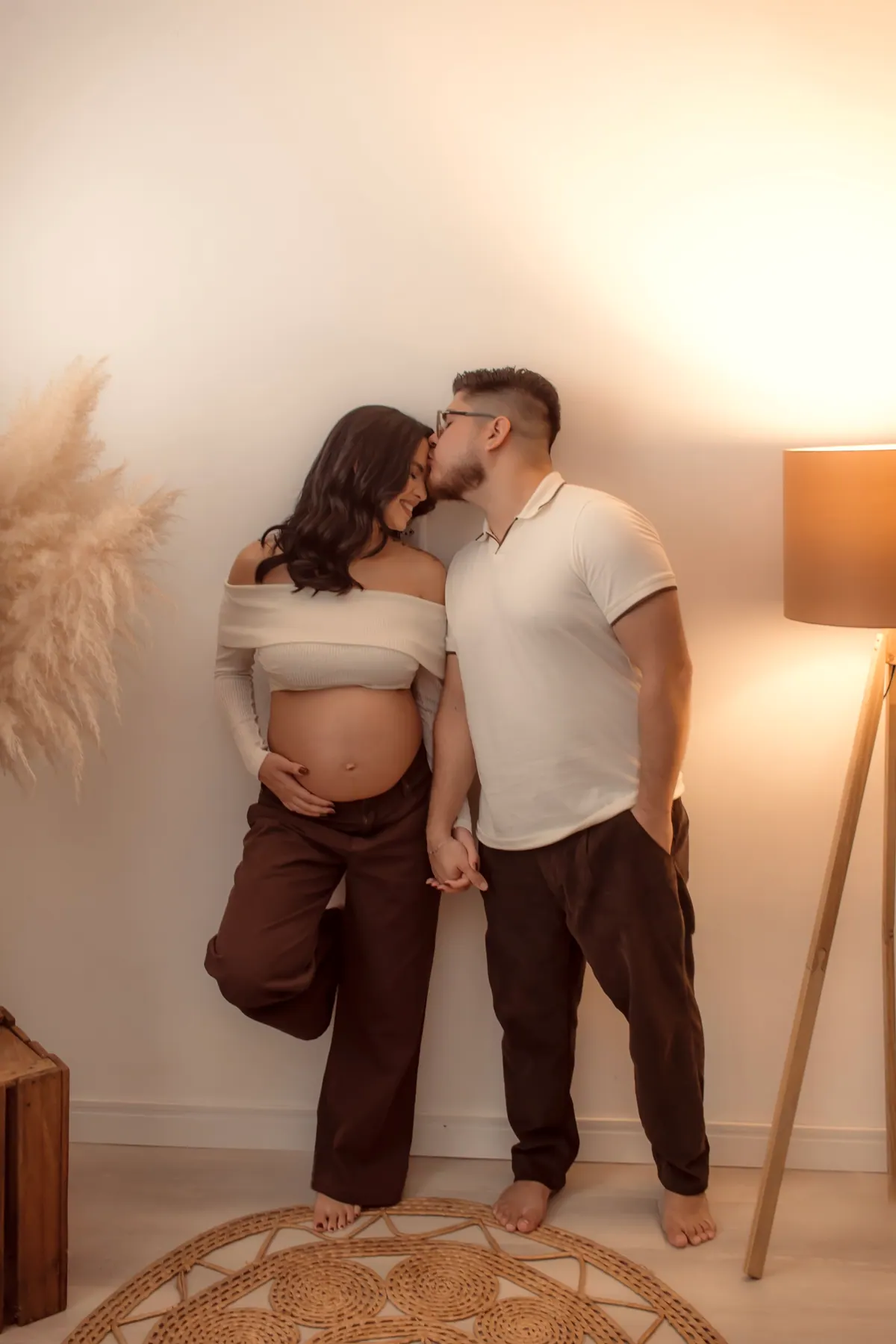 Casal se beijando no ensaio gestante, com a gestante apoiada na parede